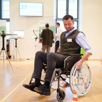 Teilnehmer des Internet Summit Austria versucht sich im Rollstuhl am Accessibility Parcours.