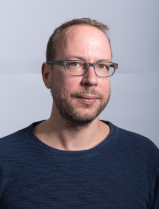 Portrait von Markus Beckedahl, er trägt eine eckige Brille und einen blauen Pullover. Er blickt freundlich in die Kamera.