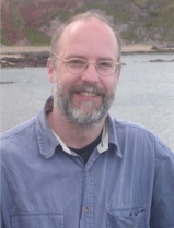 Burkhard Schafer Portrait Burkhard Schafer, freundlich lächeln, im Hintergrund ein Gewässer