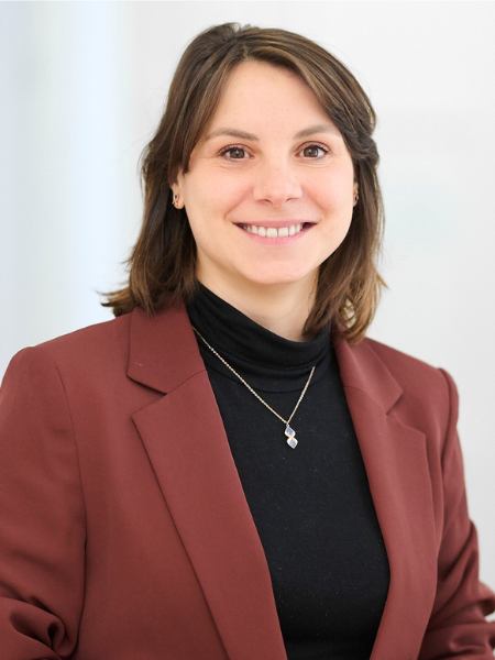 Foto von Katharina Wei&szlig;e, sie l&auml;chelt in die Kamera und sie tr&auml;gt eine dunkelrote Blazerjacke vor hellem Hintergrund