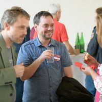 Zwei M&auml;nner und eine Frau unterhalten sich angeregt.