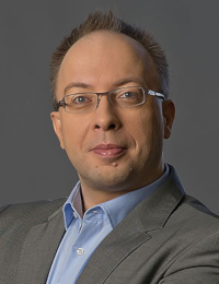 Harald Kapper, kurzes dunkelblondes Haar, mit unauff&auml;lliger Brille, tr&auml;gt ein blaues Hemd und dar&uuml;ber ein graues Sakko.