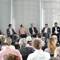 6 Vortragende sitzen auf der B&uuml;hne
